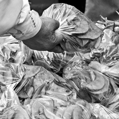 main tenant un sac au-dessus un étal de marché
